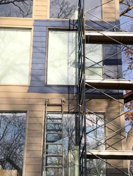 Commercial building facade on scaffolding with windows masked for painting