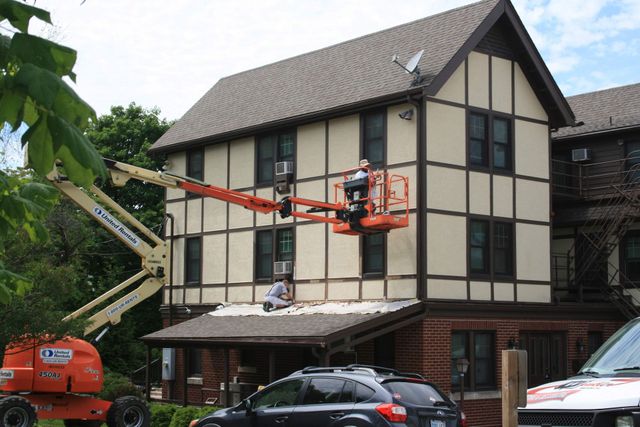 Winkler crew on a boom lift painting a Tudor-style half-timbered building