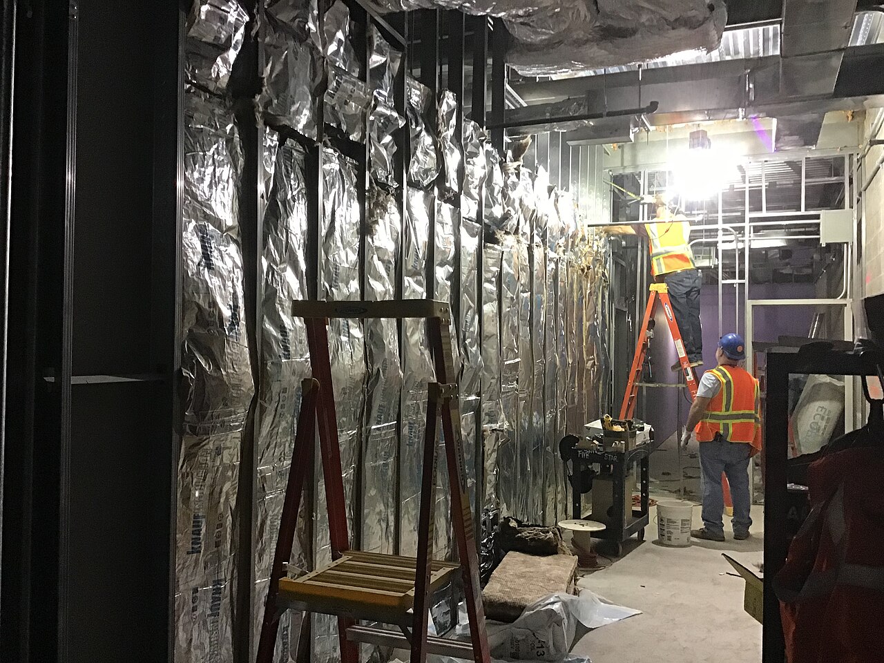 Workers installing sheetrock on a commercial drywall job